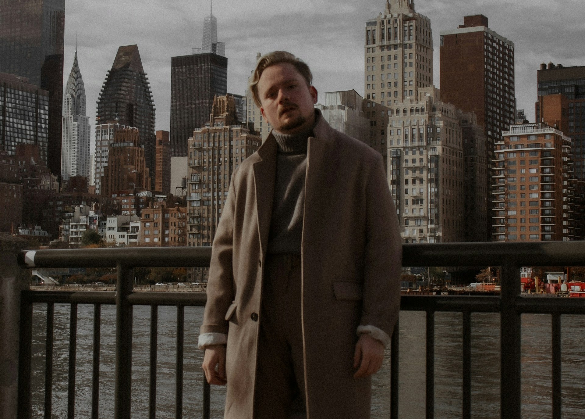 Muškarac u bež kaputu stoji u Nju Jorku