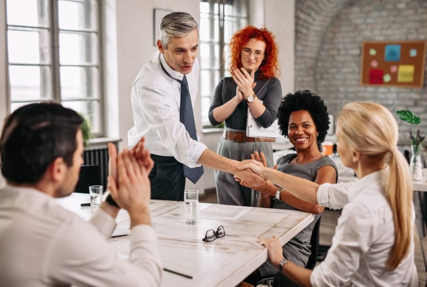 Šef se rukuje sa svojim zaposlenim tokom sastanka u kancelariji
